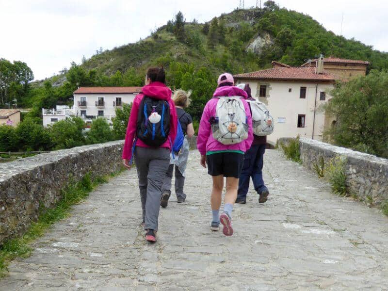 pilgrims walking the Camino on a bridge