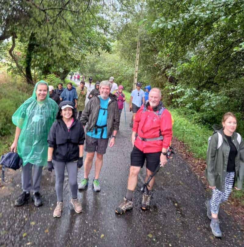 a picture of a group of pilgrims walking through the forest on the Camino