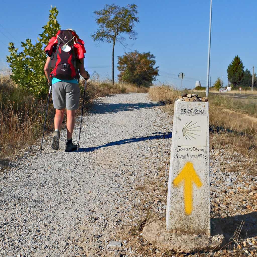 Yellow arrow and pilgrim walking